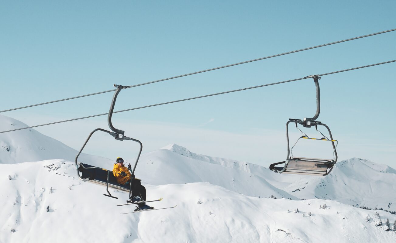 Low angle shot of a person sitting on a cable car in a snowy mountain
